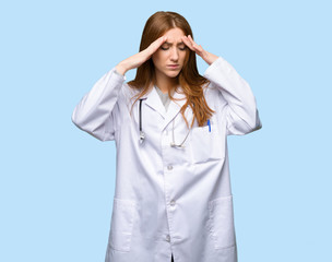 Redhead doctor woman unhappy and frustrated with something on isolated blue background
