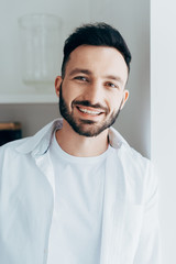 Laughing brunette man with beard looking at camera