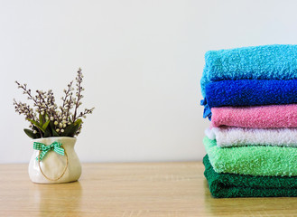 Obraz na płótnie Canvas Stack of colorful bath towels on white background.Pile of rainbow colored towels isolated.Top view.Hygiene, fabric,spa and textile concept.