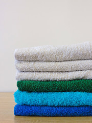 Stack of colorful bath towels  on white background.Pile of rainbow colored towels isolated.Top...
