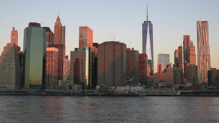Obraz premium East river and Manhattan skyline with view of urban skyscrapers at sunrise