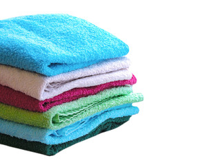 Stack of colorful bath towels  on white background.Pile of rainbow colored towels isolated.Top view.Hygiene, fabric,spa and textile concept.