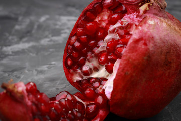 juicy ripe pieces of pomegranate on a dark background