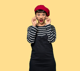 Young woman with beret with glasses and surprised
