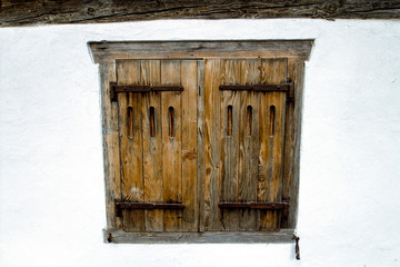 Old wooden window in a white wall.