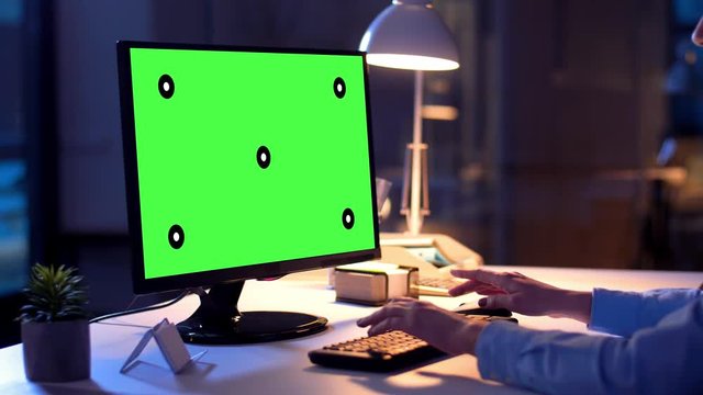 technology, virtual effects and business concept - businesswoman with chroma key green screen on computer monitor at night office