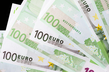 One Hundred euro banknotes on a dark background close up