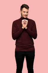 Man with turtleneck sweater scheming something over pink background