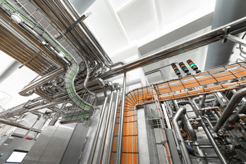 Obraz premium Steel pipelines and cables in factory interior as nuclear industry background concept