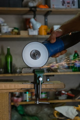 Men cuts a small metal sheet with an electric grinder