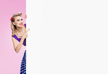 woman in pin-up style dress, showing blank signboard