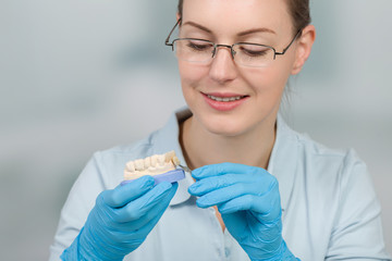 Zahnersatz wird im Zahnlabor farblich von Dentaltechnikerin überprüft