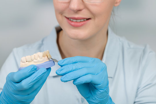 Zahnersatz wird im Zahnlabor farblich von Dentaltechnikerin überprüft