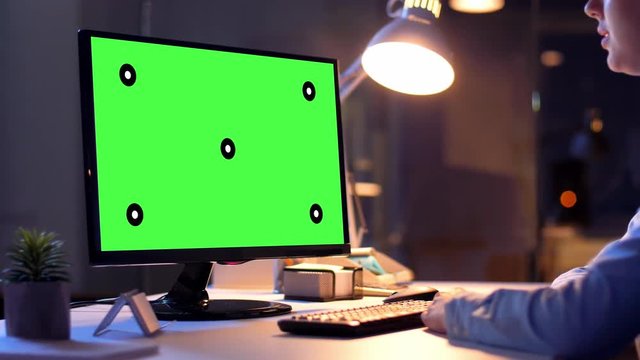 business, deadline and technology concept - businesswoman with chroma key green screen on computer monitor having video call at night office