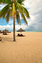Fototapeta na wymiar Two loungers on the deserted beach of Hainan Island.