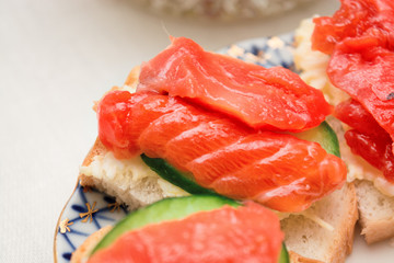 Sandwich with salmon and cucumber on a plate, selective focus