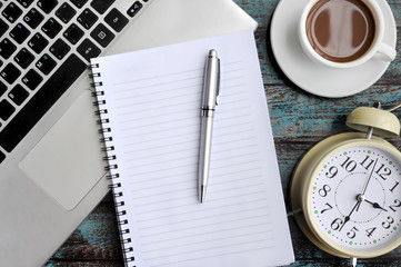 Flat Lay of Work Desk, Laptop, Coffee, Clock, Notebook and Pen on Wood Background