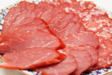 cold cuts of beams and salami on a plate, selective focus