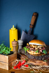Tasty grilled beef burger with  lettuce and mushrooms on a table.