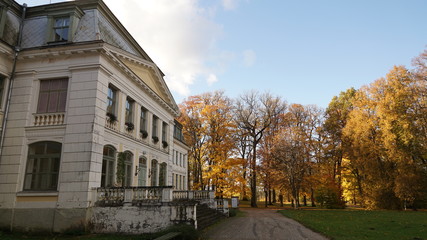 Fototapeta na wymiar 19th-century building against the background of autumn trees
