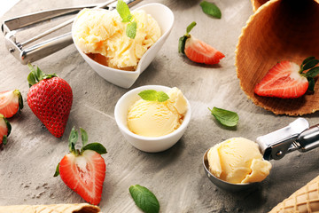 Vanilla ice cream scoop with fresh strawberries and icecream cones