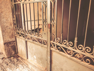 Entrance to the courtyard. Iron-forged gates decor and ornament in the city streets. Old Tbilisi architecture