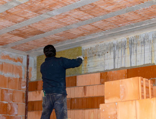 Fototapeta premium Construction of new brickwork with thermal brick blocks..In the cavity there are rock wool panels for greater thermal and acoustic insulation
