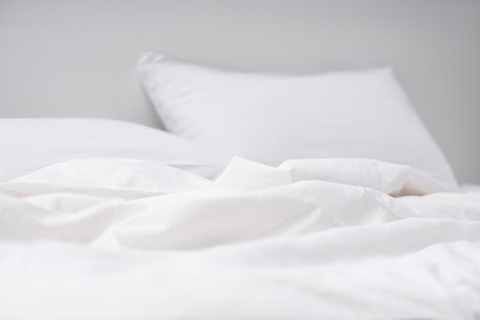 Selective Focus Of Empty Bed With White Pillows And Blanket