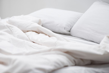 selective focus of bed with white pillows and blanket