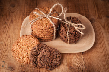 Various shortbread, oat cookies, chocolate chip biscuit on dark rustic wooden table.