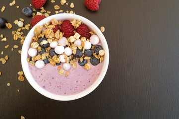 Blueberry yogurt with fresh berries on a wooden table.
