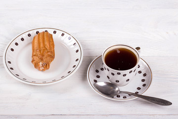Profiteroles with cream on the table with a Cup of coffee