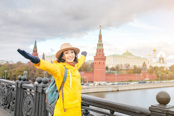 Obraz premium Happy asian woman tourist on the background of the Kremlin wall tower from the Moscow river embankment. Travel in Russia concept