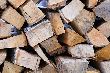 A wall of chopped fire wood stacked neatly on top of each other, background