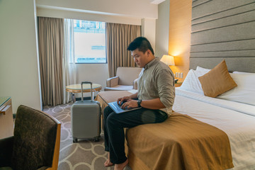 Young businessman using laptop in hotel room