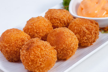 Fried cheese with saladon the white floor.