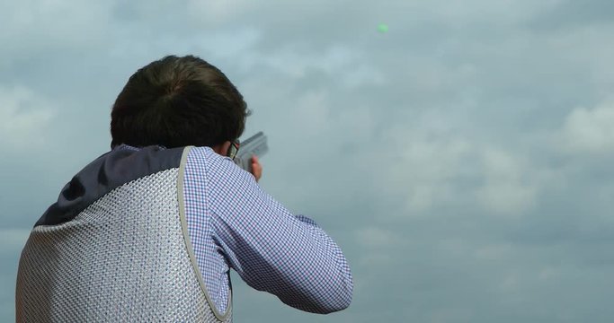 A Skeet shooter pulls the trigger and hits the target.