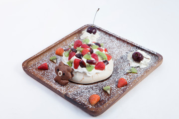 Meringue dessert on brown oak dishes on white scenes.