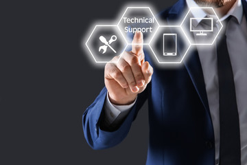 Businessman touching empty virtual screen against dark background, focus on hand