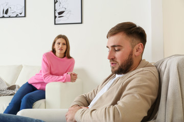 Young couple ignoring each other after argument in living room. Relationship problems