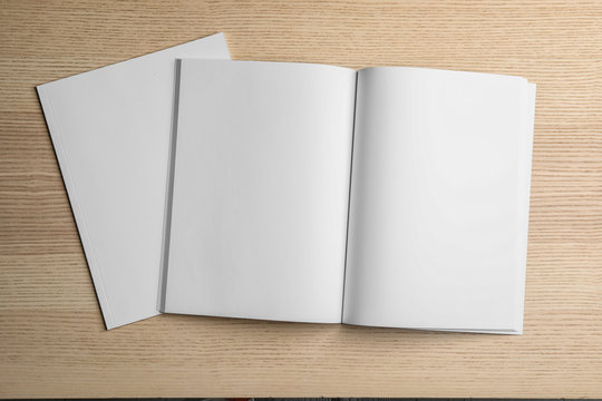 Open and closed blank brochures on wooden background, top view. Mock up for design