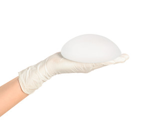 Doctor holding silicone implant for breast augmentation on white background. Cosmetic surgery