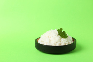 Bowl of boiled rice on color background. Space for text