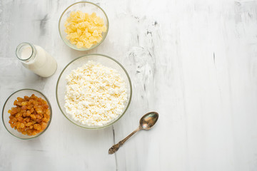 Cottage cheese with raisins and pineapple zucchini, with milk in a bowl on a white table. Diet, tasty and healthy food