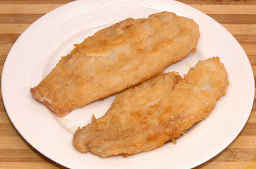 Isolated fish fillet on white dish 
