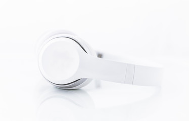 Pair of white and modern headphones isolated on white background (photo with reflection) White wireless headphones (image with mirroring effect)