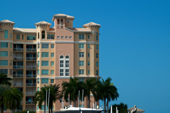 View of spanish style high rise apartment condo building over marina in Bonita Springs, Southwest, Florida