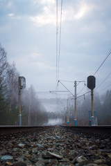 railway tracks, traffic light and electric poles in fog