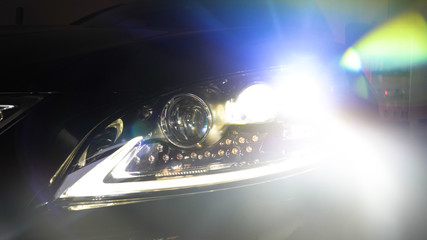 In the automobile salon (garage, center) the headlights of the car are very close, turning on (turning off) checking the front light (dimensions). Concept of: Headlight Testing, New, Diagnostics, Car.