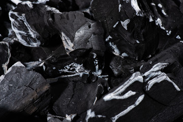 close up of black burnt textured charcoal with white ash